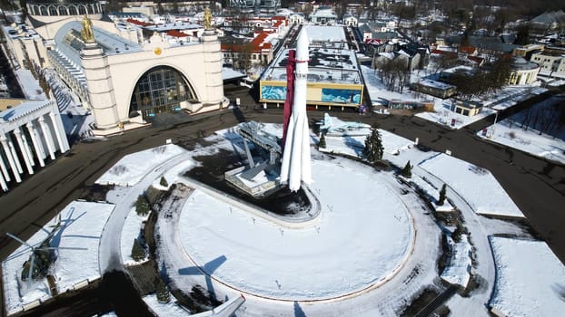 Top view of rocket monument in winter. Creative. Rocket monument on city square on sunny winter day. Large-scale monument to space flight with rocket on square.