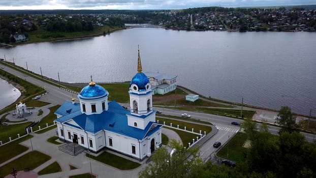 Panoramic aerial view of monastery on a summer day. Clip. Beautiful white church with blue roof near pond