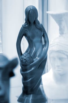 Abstract art object printed on 3D printer. Colored creative model printed on 3D printer from molten ABS PLA plastic filament. Object blue figurine of woman and child printed on FDM printer. Additive