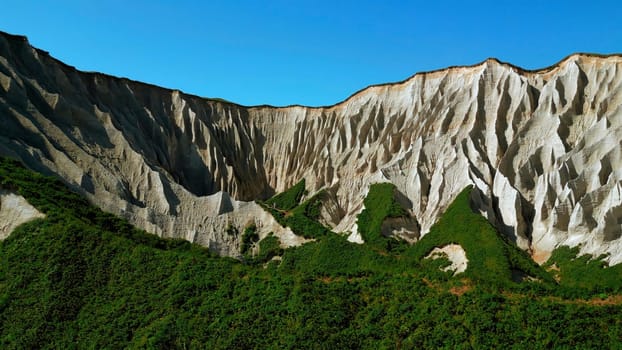 Beautiful aerial of the white cliffs on the south coast of England. Clip. Green summer forested hills and blue sky