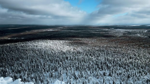 A flight over the dense winter Siberian forest in the afternoon. Clip. White mountain and a frozen weather tower on its top