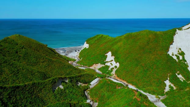 Aerial view of the Hawaiian coastline near blue sea. Clip. Paradise island covered by green vegetation