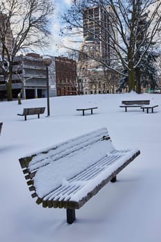 Serene winter in downtown Fort Wayne, Indiana - fresh snow blankets a quiet urban park with a historic clock tower backdrop