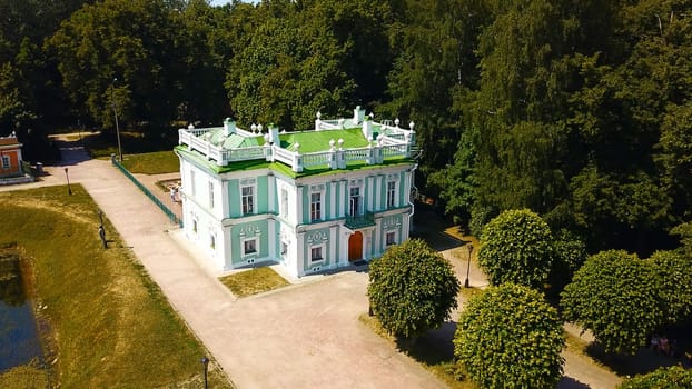 Top view of historic building with garden and pond. Creative. Beautiful park and garden with Baroque estate. Tourists walk in historical park with ancient building.