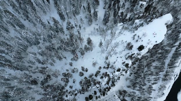 Aerial view of high stone formations in winter forest. Clip. Exploring frozen winter nature, concept of adventure