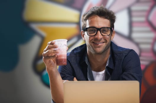 Portrait, drink or man on laptop for research, information and email for blog, article and copywriting in a startup. Journalist, freelancer or creative writer on break in modern office with smoothie.