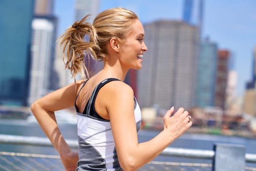 Woman, excited and running for fitness in city, jogging active and fit female person exercising in New York. Energy, marathon for sports training and workout for athlete, cardio wellness or endurance.