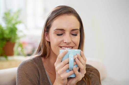 Coffee, happy and woman in home on sofa with drink, hot beverage and caffeine for breakfast. Morning, apartment and person with tea, mug and calm for relaxing, wellness and health in living room.