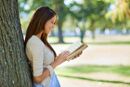 Happy woman, park and reading book for learning, education or leisure in summer. Young person with story, fiction or literature for language, knowledge and studying or creative inspiration in nature.
