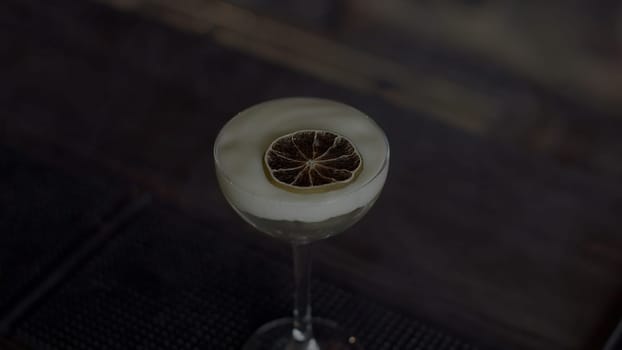 Close up of cocktail with a slice of dried orange fruite in smoke. Media. Concept of party at a bar or night club