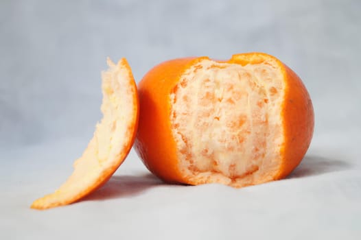 A peeled orange with a bite taken out of it. High quality photo