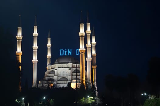 A large white mosque with a blue sign. High quality photo