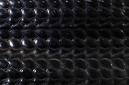 A close up of a black leather item with a pattern of small black dots. High quality photo