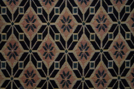 A patterned carpet with a black and brown color scheme. High quality photo