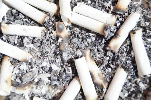 A pile of cigarette butts and ash on the ground. High quality photo
