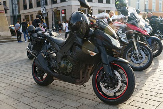 Warsaw, Poland - August 6, 2023: A black Kawasaki motorcycle is parked in the square next to other motorcycles.