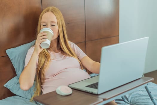 Resourceful pregnant woman works from the cozy confines of her bed at home, combining productivity with a comforting coffee break during the remote work session.