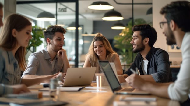 A lively team gathers around a laptop, engaging in a collaborative discussion in a well-lit, modern office setting. AIG41