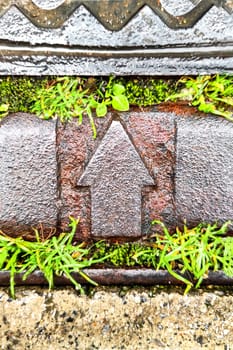 Metal Arrow Up Surrounded by Green Grass, Symbol of Harmonious Fusion of Modern Technology and Nature, Concept of Direction and Movement, and Path to Development and Progress, Vertical Frame