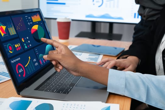 Multiracial analyst team use BI Fintech software to analyze financial data on meeting table. Financial dashboard data display on laptop screen with analyzed chart for marketing indication. Concord