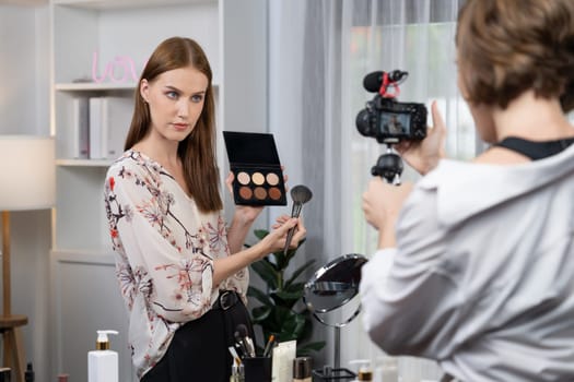 Woman influencer shoot live streaming vlog video review makeup utmost social media or blog. Happy young girl with cosmetics studio lighting for marketing recording session broadcasting online.