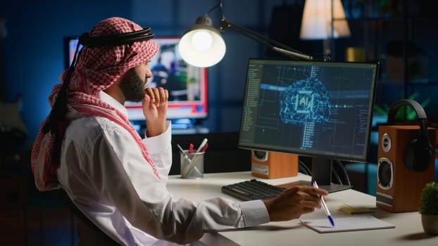 Man in home office typing on keyboard, updating artificial intelligence neural networks, writing complex binary code scripts. Muslim freelancer in personal office upgrading high tech AI