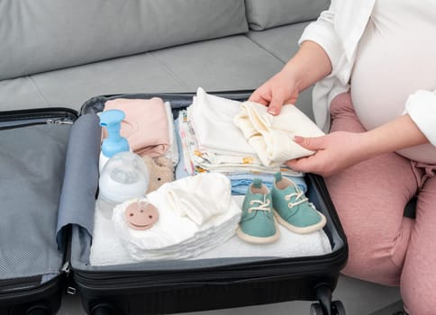 Cute new things for the maternity hospital are packed by a pregnant woman.