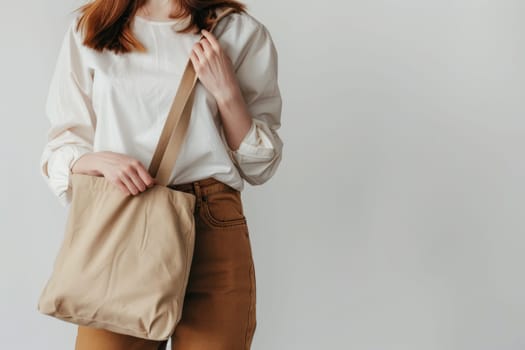 Close up of woman with tote bag mockup on white studio background.