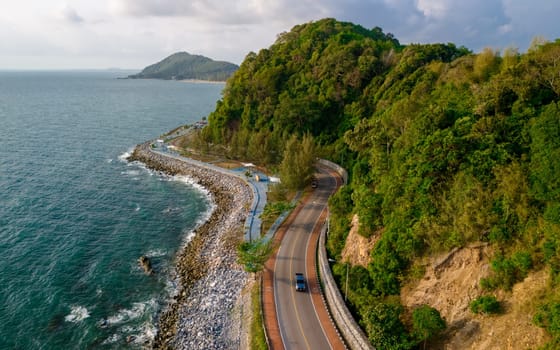 car driving on the curved road of Thailand. road landscape in summer. it's nice to drive on the beachside highway. Chantaburi Province Thailand, blue ocean with a curved road in the mountains