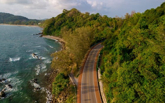 car driving on the curved road of Thailand. road landscape in summer. it's nice to drive on the beachside highway. Chantaburi Province Thailand, drone view at the road in the mountains