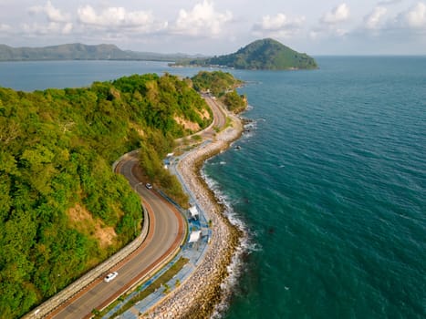 car driving on the curved road alongside the ocean beach road of Thailand. road landscape in summer. it's nice to drive on the beachside highway. Chantaburi Province Thailand in summer