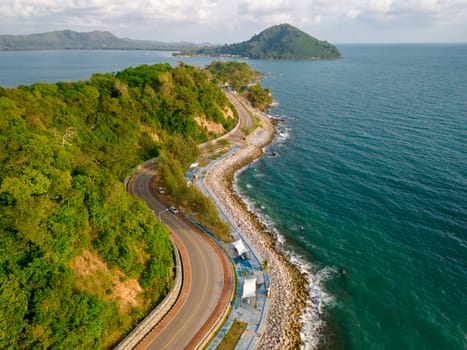 car driving on the curved road alongside the ocean beach road, road landscape in summer. it's nice to drive on the beachside highway. Chantaburi Province Thailand,