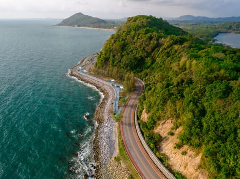 drone view at a curved road alongside the ocean beach road of Thailand. road landscape in summer. it's nice to drive on the beachside highway. Chantaburi Province Thailand,