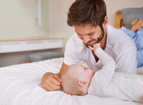 Happy, bonding and baby with father on bed relaxing, playing and resting together at home. Smile, love and young dad laying with girl child, infant or kid in bedroom or nursery at family house
