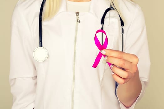 Female Doctor Holds Pink Ribbon, International Breast Cancer Day October 7 - Image