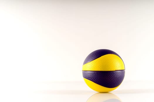 Basketball ball with yellow and purple spots on a white background. Antistress ball