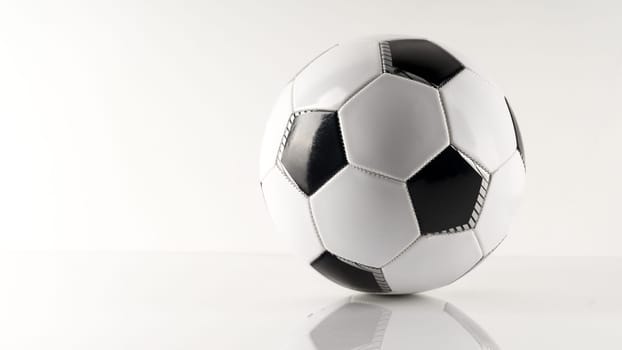 Classic soccer ball, typical black and white pattern, isolated on white background. Traditional soccer ball symbol, real studio photo.