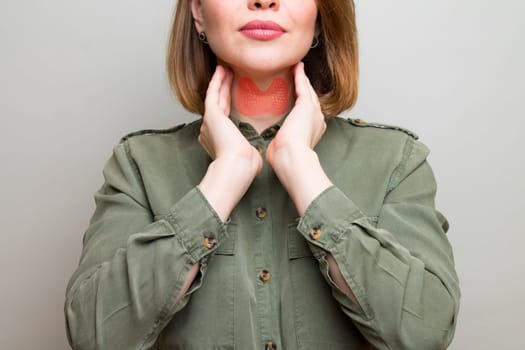 Female checking thyroid gland by herself. Thyroid disorder includes goiter, hyperthyroid, hypothyroid, tumor or cancer. Health care