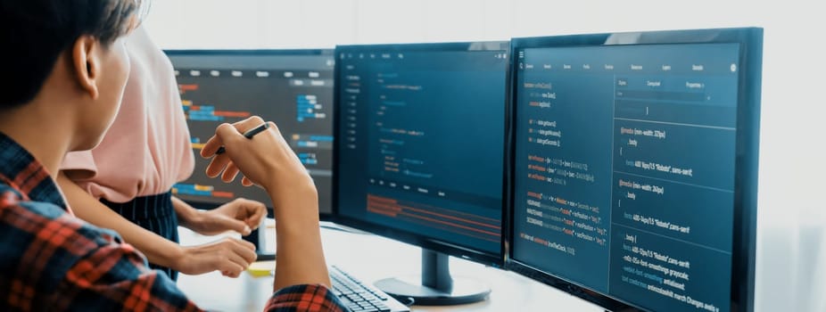 Cropped image of professional programer team collaboration discuss about web coding while coworker point java script displayed on computer at modern company office. Closeup. Burgeoning.