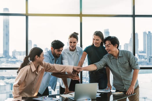 Group of multicultural businesspeople putting hands together at modern office. Happy smart business team working together. Represented unity, working together, partnership, work place. Tracery.