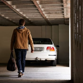 Parking, garage and man travel in car for morning commute or transportation for vacation on holiday. Luggage, bag and person with motor journey to work or walking in underground lot to parked vehicle.