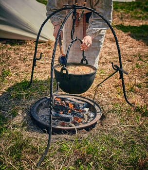 Camping. Soup in a pot over a fire. Stylization under the Middle Ages, vintage.