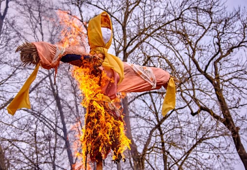 A traditional effigy is set on fire in a rural pasture to celebrate the arrival of spring in the countryside.