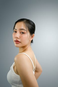 Attractive young woman posing and looking at camera on white at the photo studio.