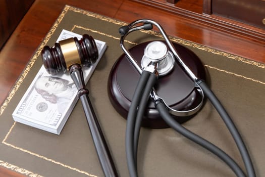 An image depicting a judge's gavel, a medical stethoscope, and a stack of US currency, highlighting the costly nature of legal and medical services