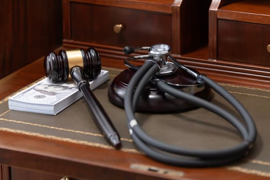 An image depicting a judge's gavel, a medical stethoscope, and a stack of US currency, highlighting the costly nature of legal and medical services