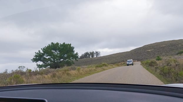 In this serene winter scene, a vehicle carefully makes its way along Los Osos Valley Road and Pecho Valley Road within Montana de Oro State Park.