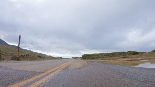 In this serene winter scene, a vehicle carefully makes its way along Los Osos Valley Road and Pecho Valley Road within Montana de Oro State Park.