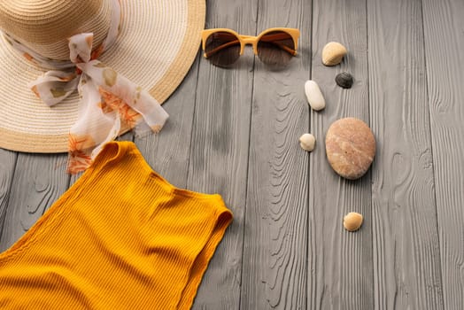 beachwear orange woman top outfit hat bag sun protection sunglasses pebbles. Summer background template mockup free space composition sample text. Top view above wooden background vacation concept