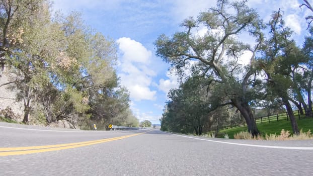 Vehicle is cruising along the Cuyama Highway under the bright sun. The surrounding landscape is illuminated by the radiant sunshine, creating a picturesque and inviting scene as the car travels through this captivating area.